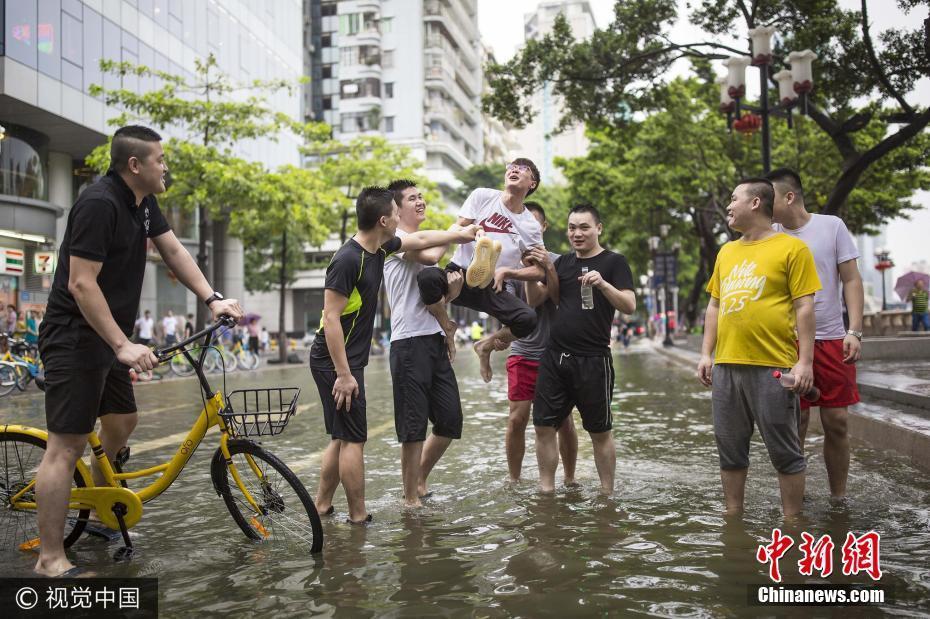 臺(tái)風(fēng)來襲珠江水倒灌 市民街頭嬉戲撈魚樂趣十足