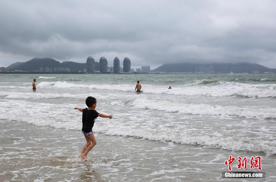 臺(tái)風(fēng)“山神”橫穿海南 游客不懼風(fēng)雨海邊戲水