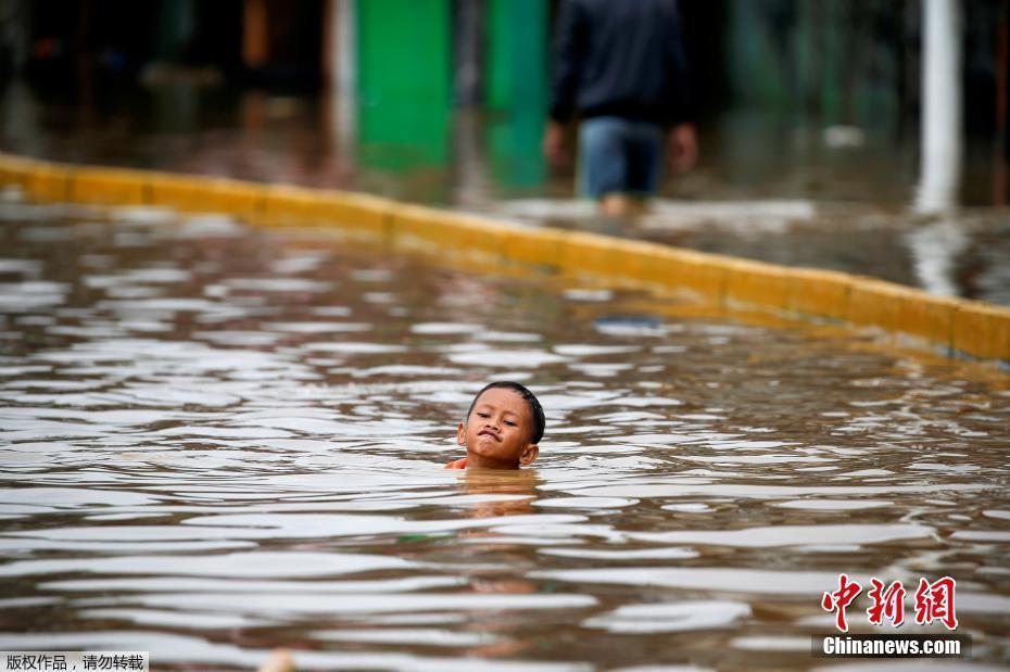 印尼首都雅加達(dá)遭暴雨侵襲 兒童在洪水里“苦中作樂(lè)”