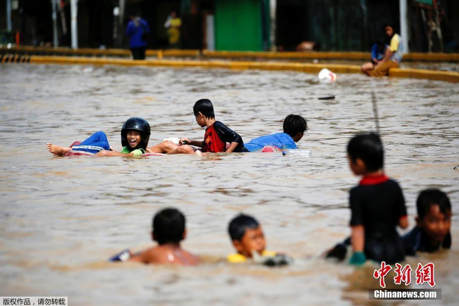 印尼首都雅加達(dá)遭暴雨侵襲 兒童在洪水里“苦中作樂(lè)”