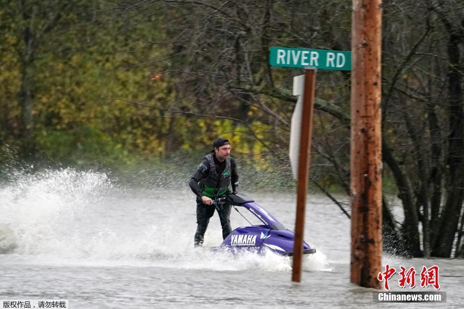美国华盛顿州路面被淹 民众骑摩托艇出行