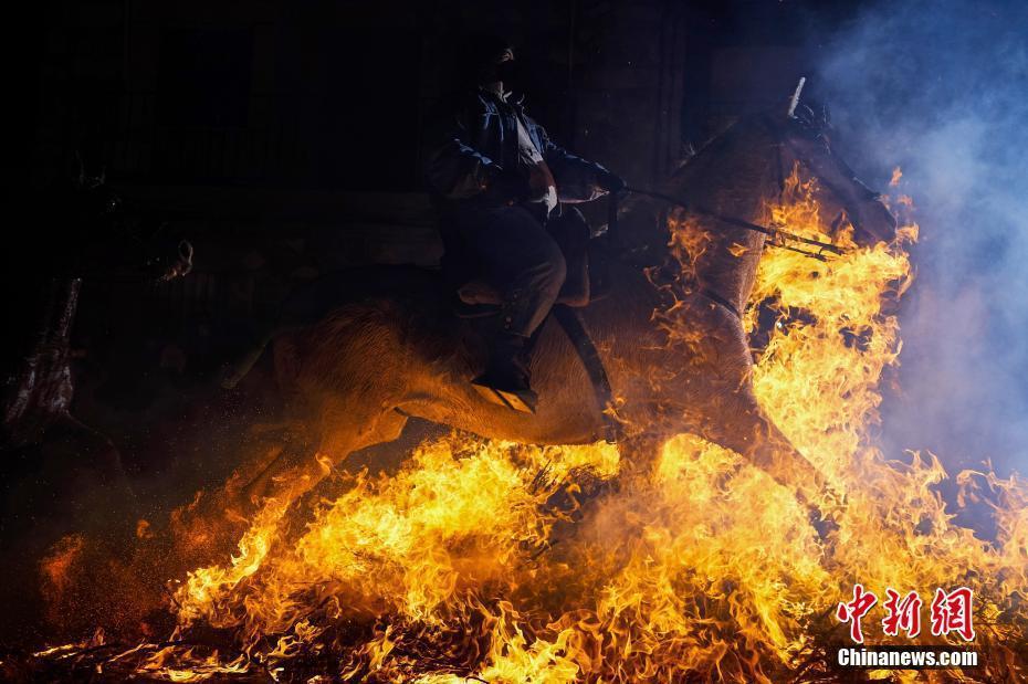 西班牙小镇举行传统节日 民众骑马跳过熊熊大火祈愿平安