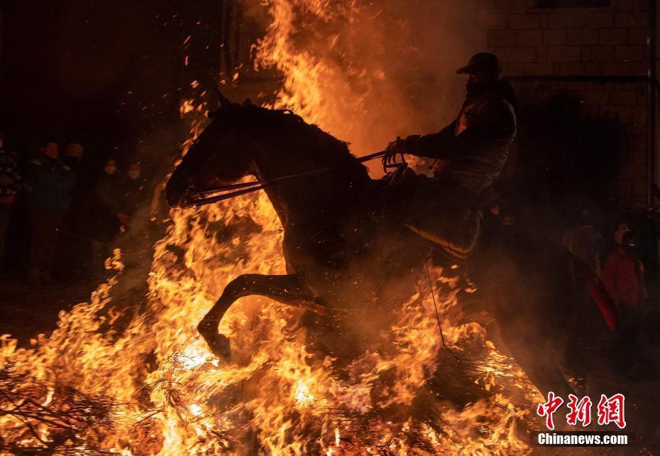 西班牙小镇举行传统节日 民众骑马跳过熊熊大火祈愿平安