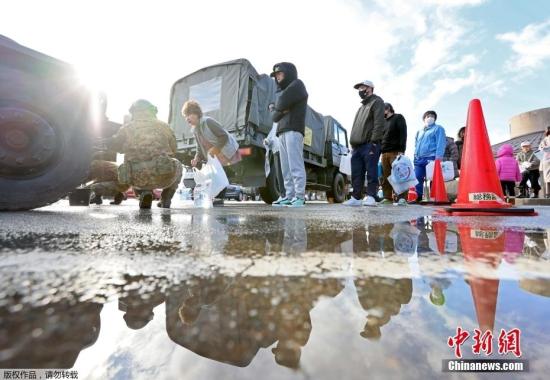 震后日本民眾排隊取水領取食物購買物品