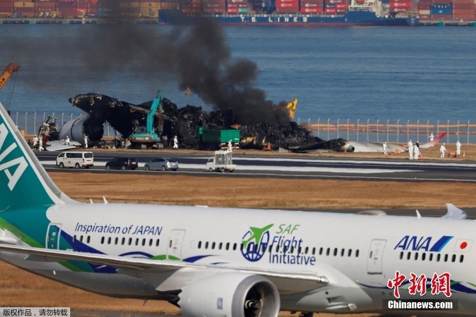 日本東京羽田機(jī)場清理飛機(jī)殘骸時(shí)再冒濃煙