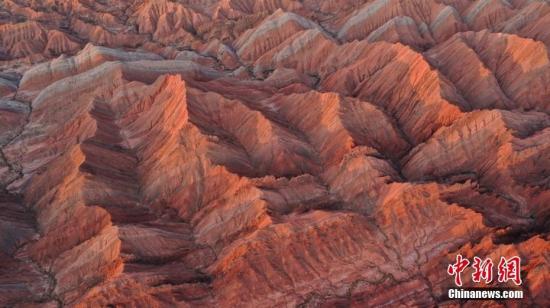 新疆庫(kù)車(chē)：紅山石林奇峰嶙峋 光影勾勒奇幻世界