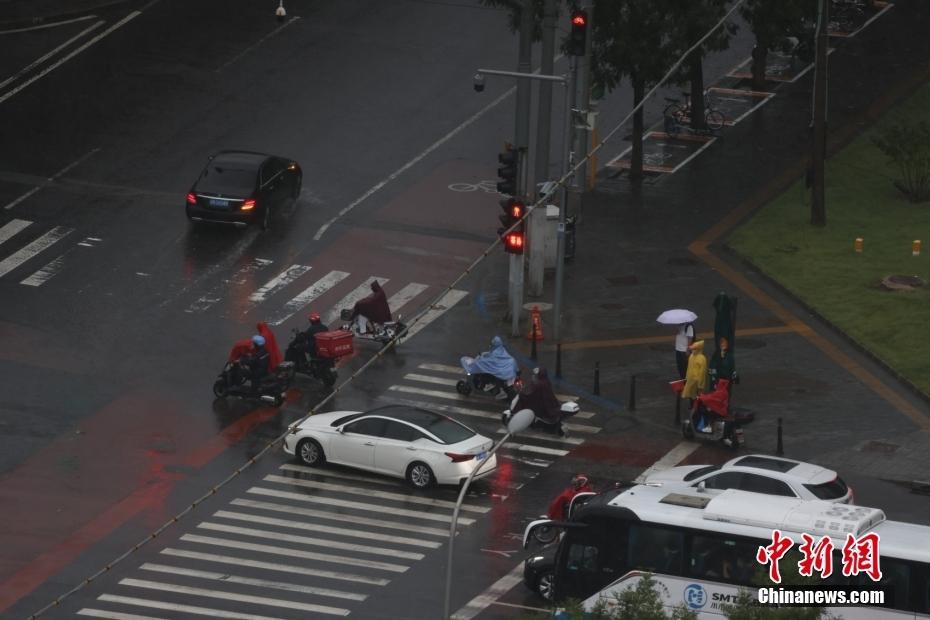 北京發(fā)布暴雨藍(lán)色預(yù)警 民眾冒雨出行