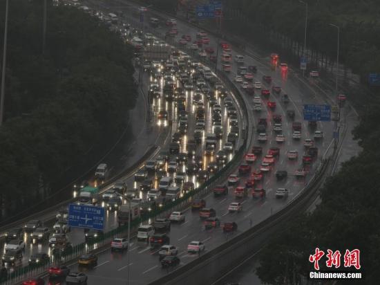 北京發(fā)布暴雨藍色預(yù)警 民眾冒雨出行