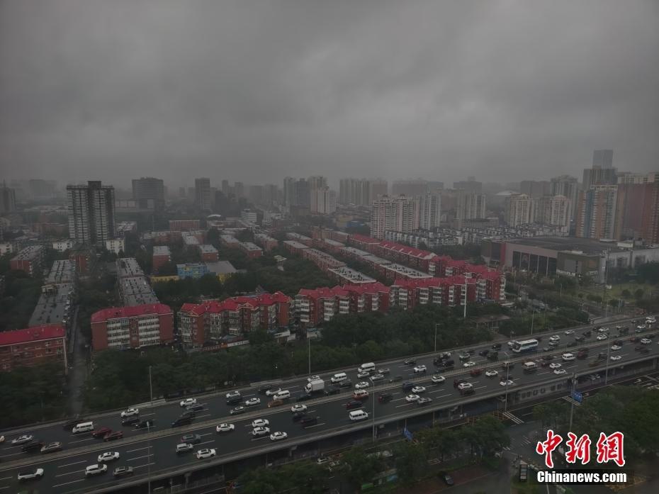 北京發(fā)布暴雨藍色預警 民眾冒雨出行