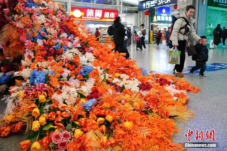 云南昆明：花朵織孔雀 扮靚春運路